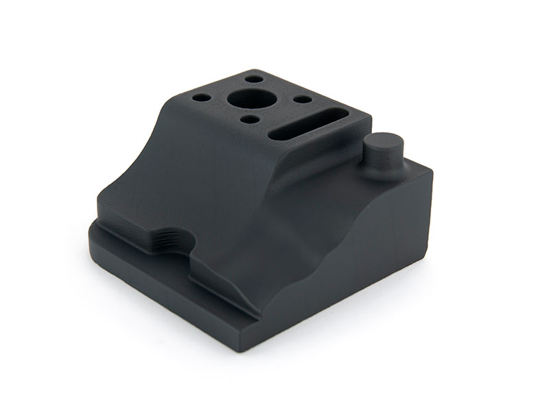 Componente técnico industrial preto com furos de fixação e encaixes precisos, impresso em resina rígida HAN Mold via SLA a laser, fotografia de produto em ângulo isométrico sobre fundo branco